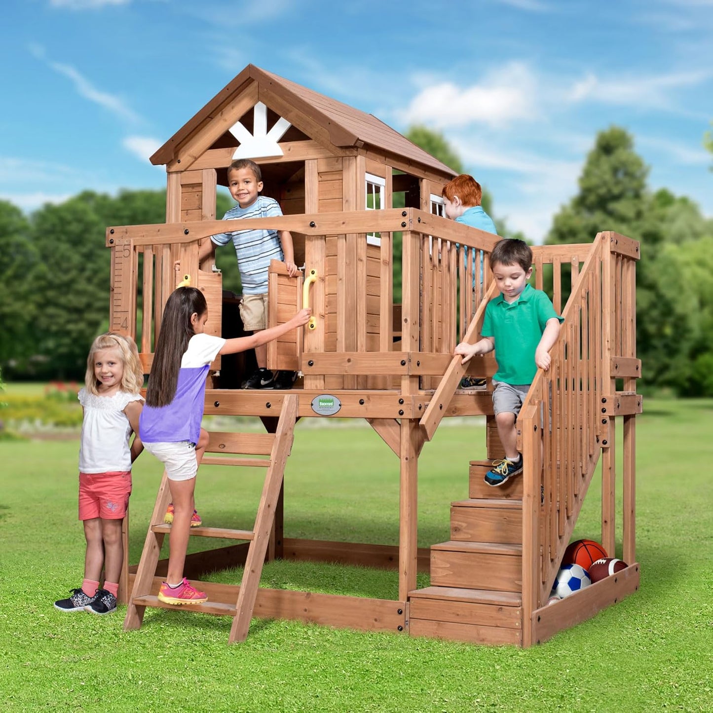 Scenic Heights Elevated Cedar Wooden Kids Playhouse with Play Kitchen, Wrap-Around Deck, Toy Storage Bench, Saloon-Style Doors, Ladder, Stairs, and Growth Chart for Outdoor Play